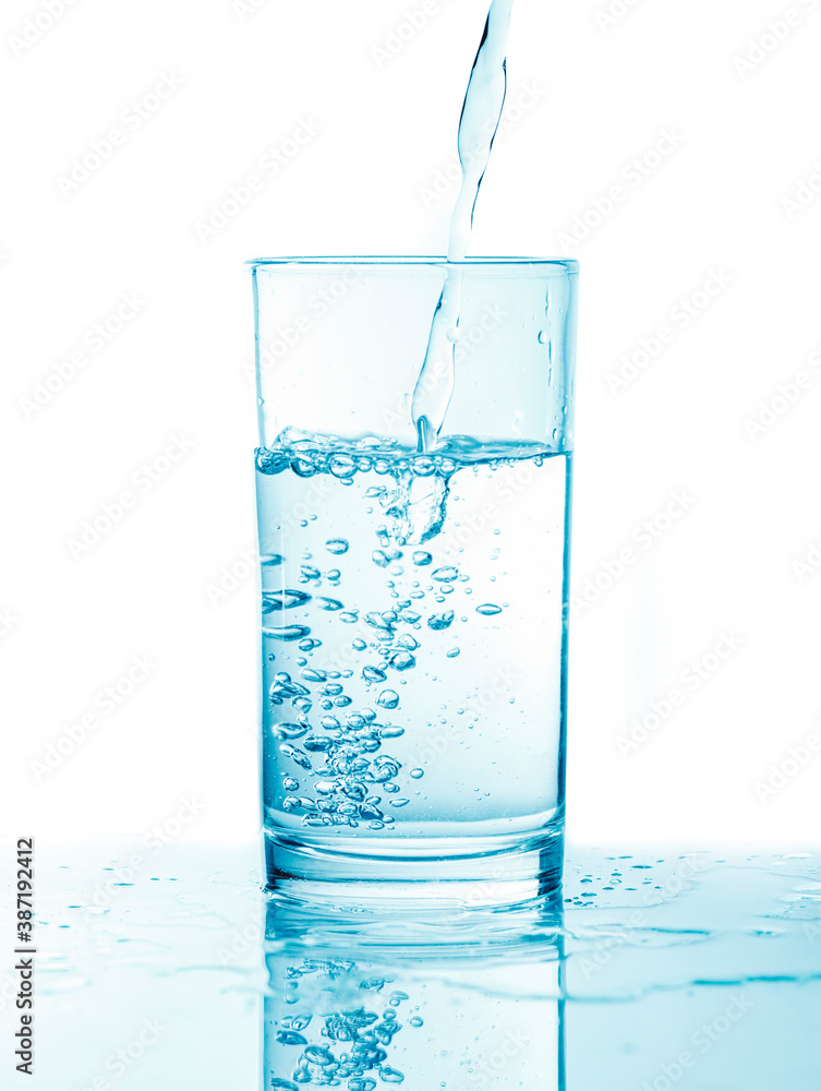 Pouring water into glass in blue toning Pouring water into glass in blue toning