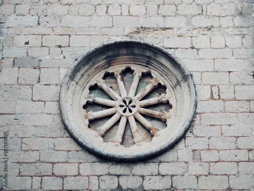 
Vintage round window on grey brick wall