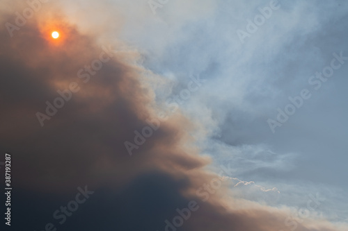 Smoke flume from the Cameron Peak fire in Colorado partially obscures an orange tinted sun