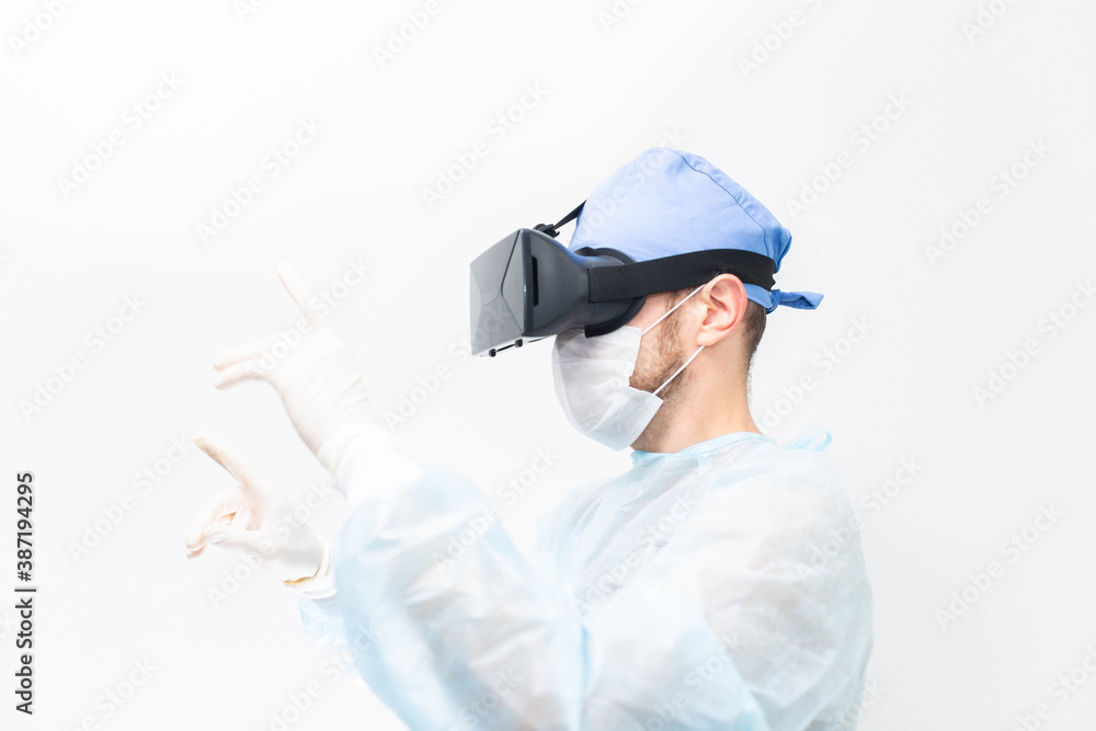 male doctor surgeon in uniform and VR glasses helmet, the use of virtual reality in medicine. Modern technologies in teaching. male doctor surgeon in uniform and VR glasses helmet, the use of virtual reality in medicine. Modern technologies in teaching.