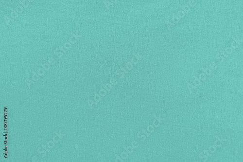 Turquoise homogeneous background with a textured surface, fabric.