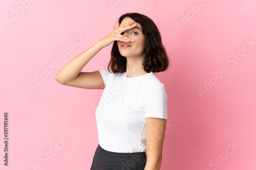 Teenager Ukrainian girl isolated on pink background covering eyes by hands and smiling