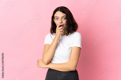 Teenager Ukrainian girl isolated on pink background surprised and shocked while looking right