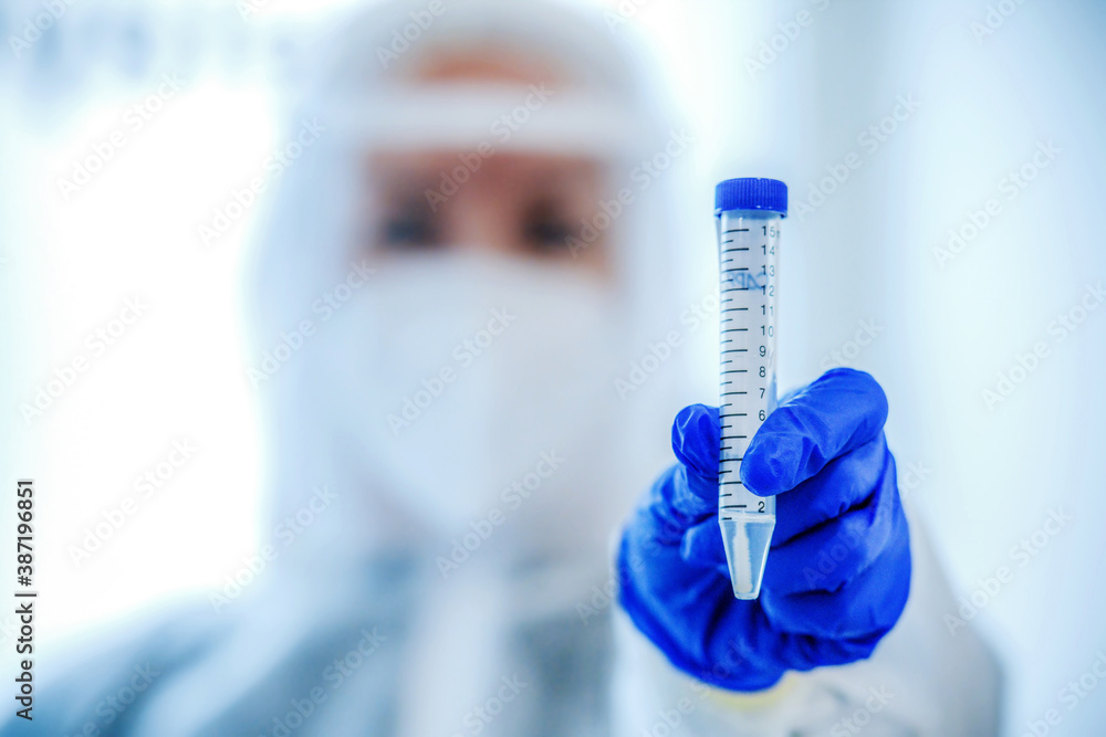 Coronavirus epidemic in the world, a nurse in a respiratory mask holds a test tube with sample Coronavirus epidemic in the world, a nurse in a respiratory mask holds a test tube with sample