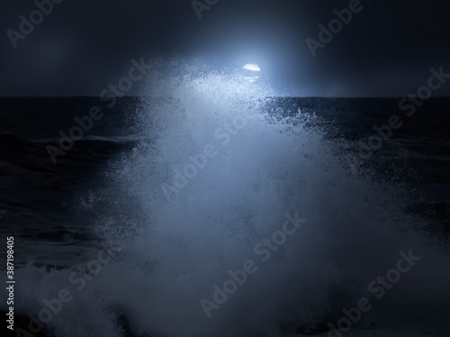 Wave splash in a cloudy full moon night