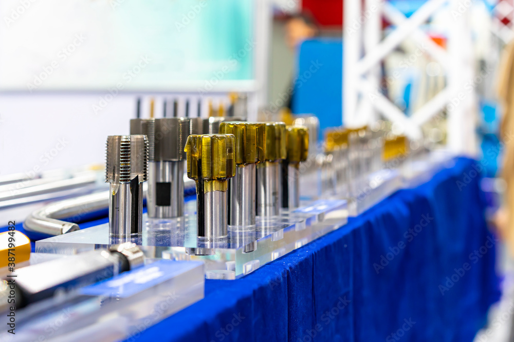 New and precision metal tapping cutting tools for threaded hole making with rust resistant coating in manufacturing process on table New and precision metal tapping cutting tools for threaded hole making with rust resistant coating in manufacturing process on table