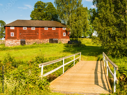 Hofgebäude rot Garten Bäume Holzbrücke photo