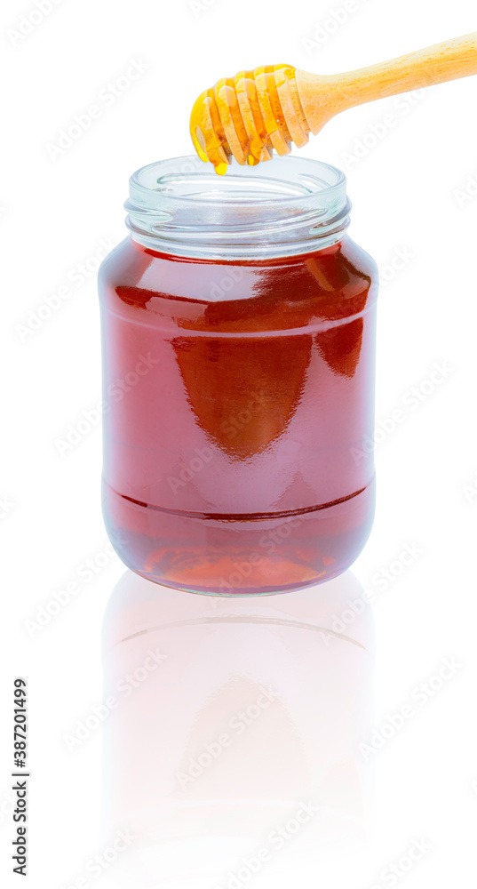 Honey dripping from a honey dipper in a glass cup Honey dripping from a honey dipper in a glass cup