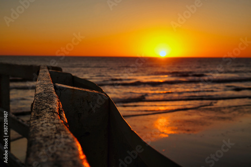 Sunrise from an old wooden pier in La Lucila beach, Buenos Aires photo