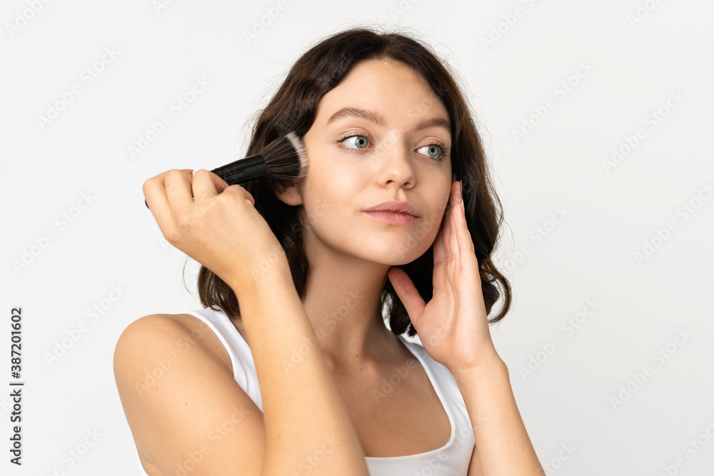 Teenager Ukrainian girl isolated on white background holding makeup brush Teenager Ukrainian girl isolated on white background holding makeup brush