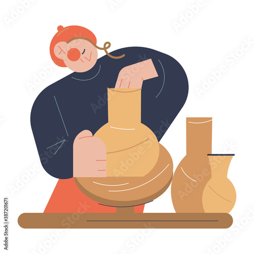Man artist sitting and making clay jug on potters wheel in pottery studio
