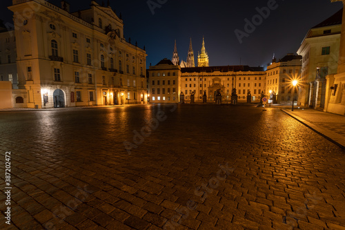  lit street light in a city street at night. glowing lamp at night in the old town of prague in the czech republic  and in the background the view of the city of Prague at night and the  