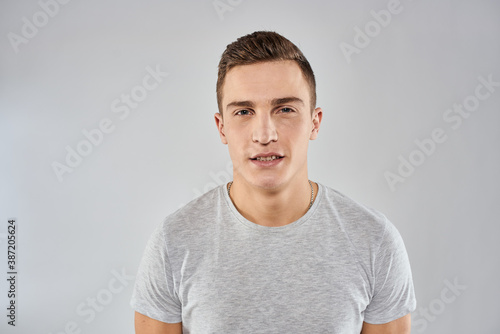 handsome man in light t-shirt cropped view emotion studio isolated background