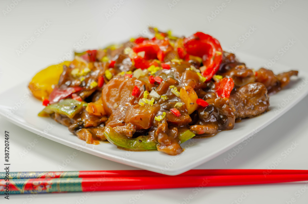 Cooked marinated beef slices with a savory black beef sauce, peppers and onions Cooked marinated beef slices with a savory black beef sauce, peppers and onions