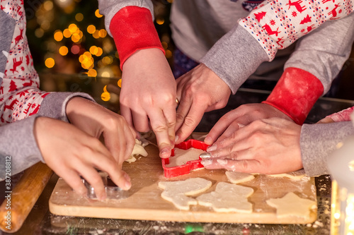 Children cut out cookies from raw dough with a cookie cutter.