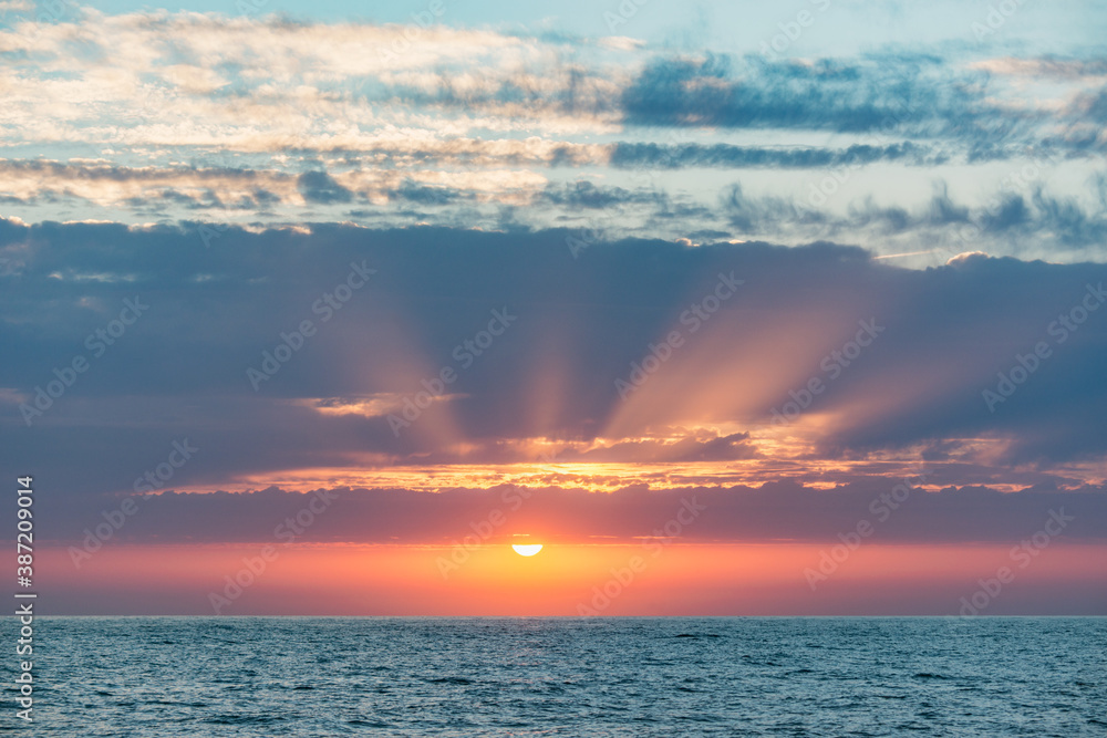 Sunset sky over the calm surface of the sea.