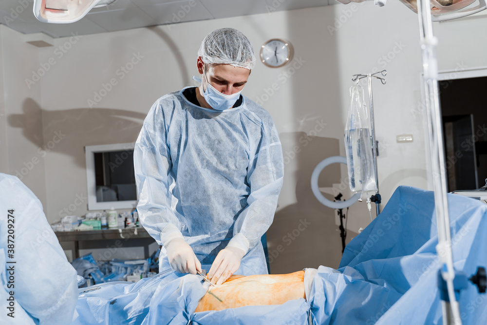 Abdominoplasty - plastic operation to reduce the abdomen and remove cellulite. Correcting body shape. Surgeon does liposuction for patient in medical clinic Abdominoplasty - plastic operation to reduce the abdomen and remove cellulite. Correcting body shape. Surgeon does liposuction for patient in medical clinic