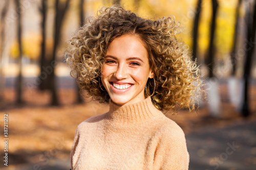 Canvas Print Hairstyle curly hair, portrait of a young blonde girl in an autumn park