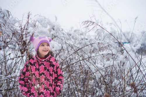 A little happy girl in bright winter clothes