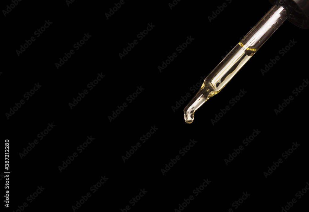 Pipette with cosmetic oil on a dark background. A bottle of cosmetics. Skin, hair, and body care. Spa. Free space for text. Pipette with cosmetic oil on a dark background. A bottle of cosmetics. Skin, hair, and body care. Spa. Free space for text.