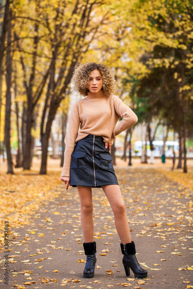 Portrait of a young beautiful girl in beige sweater and black skirt Portrait of a young beautiful girl in beige sweater and black skirt