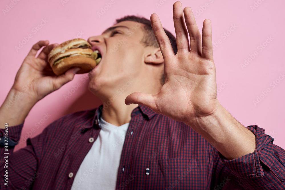 hungry man with hamburgers in hands fast food diet food emotions pink background hungry man with hamburgers in hands fast food diet food emotions pink background