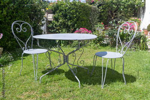Φωτογραφία Table and chairs made in wrought iron in a garden