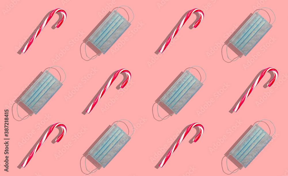 Merry Christmas candy in series along with a medical facial mask representing Christmas with covid and coronavirus. Christmas and covid concept. Merry Christmas candy in series along with a medical facial mask representing Christmas with covid and coronavirus. Christmas and covid concept.