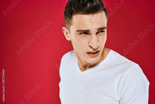 Emotional man white t-shirt displeased facial expression red isolated background cropped view