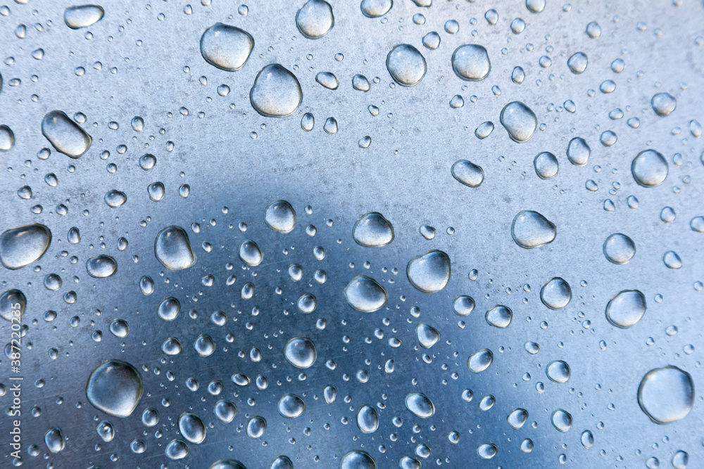 Water drops on a metal surface, background, shallow depth of field.