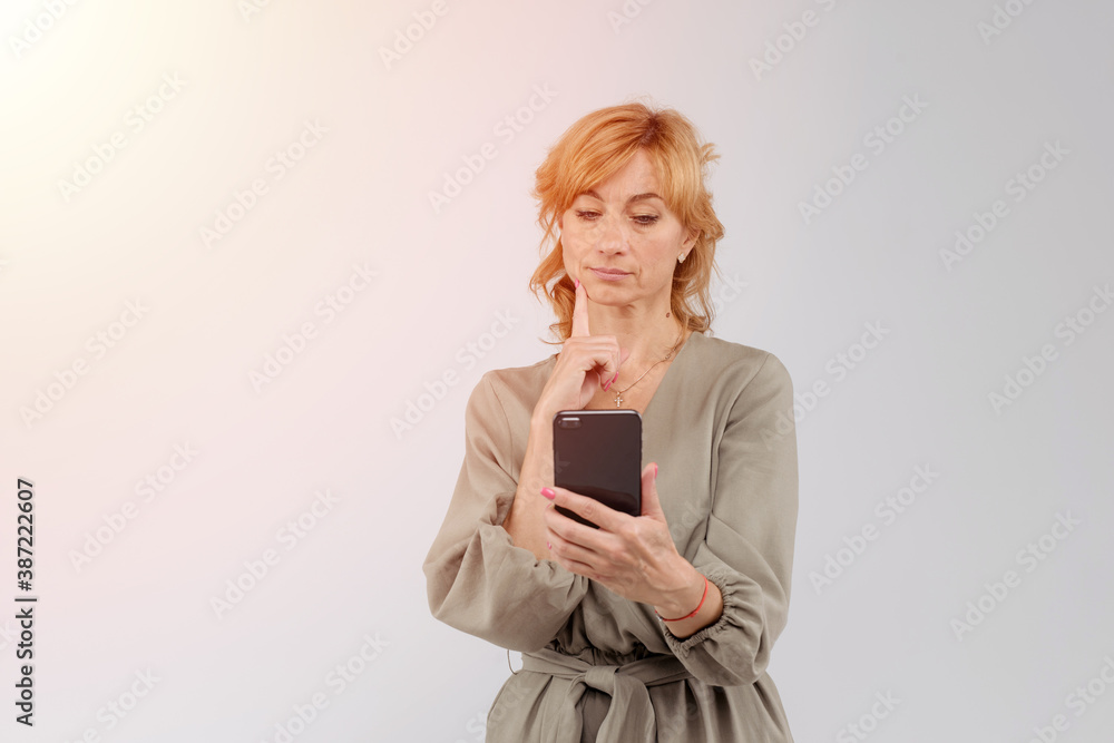 Closeup portrait of a business woman, corporate employee looking at cell phone, looking to bad text message, email, isolated on white background. Negative human emotion facial expression reaction Closeup portrait of a business woman, corporate employee looking at cell phone, looking to bad text message, email, isolated on white background. Negative human emotion facial expression reaction
