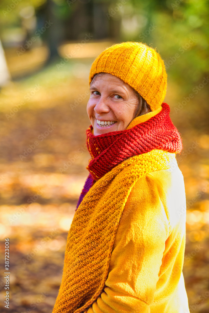 woman in her 50s walking in park in autumn woman in her 50s walking in park in autumn