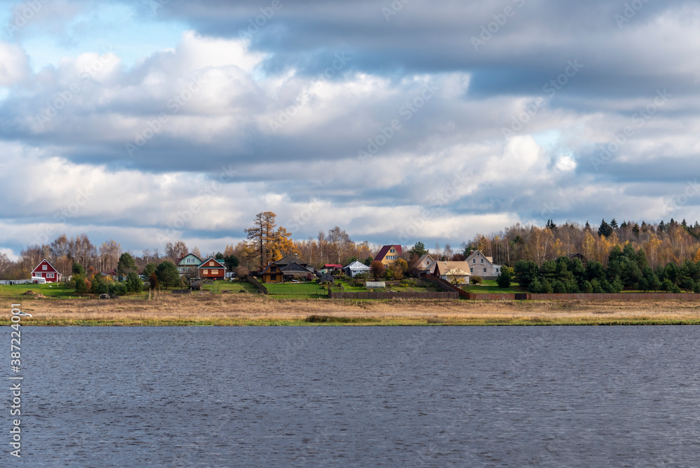Village by the river. Rural autumn landscape.