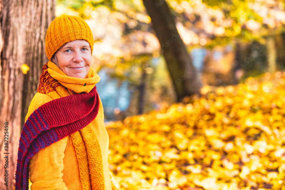 woman in her 50s walking in park in autumn