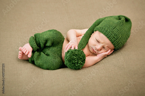 sleeping newborn baby boy in green cap