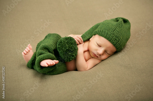 sleeping newborn baby boy in green cap