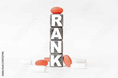 a group of white and red pills and cubes with the word rank on them, white background. Concept carehealth, treatment, therapy. photo