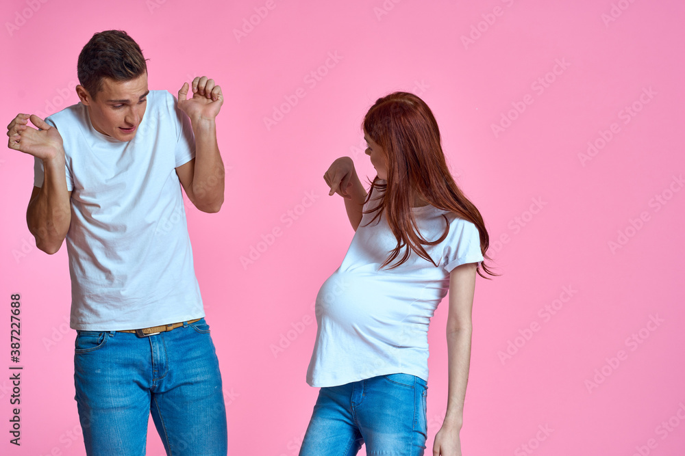 pregnant mom and happy father on pink background Young family waiting for baby pregnant mom and happy father on pink background Young family waiting for baby