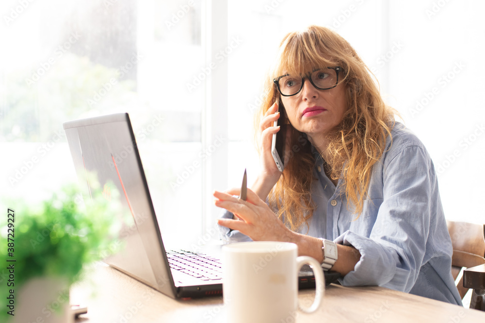 adult business woman with mobile phone and laptop working at home or office adult business woman with mobile phone and laptop working at home or office