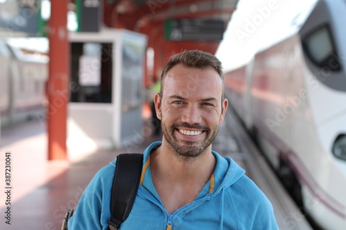 Blonde man smiling in train station