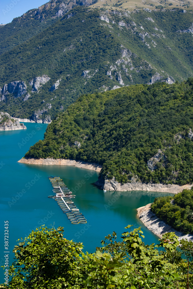 Beautiful landscape Mountain lake of azure color. Oyster farm. View from above. Sunny day, clouds. Montenegro.