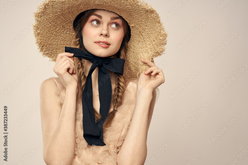 romantic girl in beige dress and in straw hat with black ribbon emotions portrait of model cropped view
