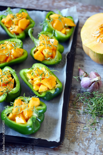 Selective focus. Green peppers stuffed with pumpkin pieces. Autumn dishes. Healthy food. Vegan lunch.