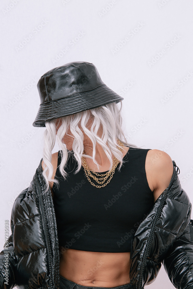  Sexy blonde model in fashion urban street outfit. Trendy black bucket hat and bomber. Daring Jewelry  Stylish Fall winter seasons. Rap hip hop vibes - obrazy, fototapety, plakaty 