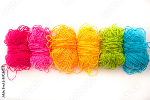 multicolored threads lie on a white background top view