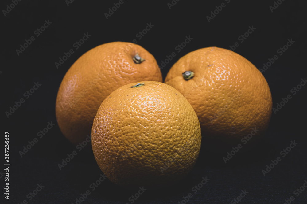 three oranges with black background three oranges with black background