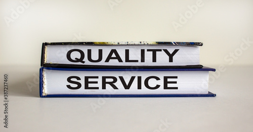 Books with text 'quality service' on beautiful white background. Business concept. Copy space.