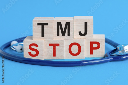 Wallpaper Mural Wooden block with words TMJ Stop - with stethoscope on the table, insurance and medical concept, blue background Torontodigital.ca