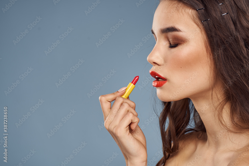 Woman with lipstick on a gray background brunette makeup with eye shadow on the eyelids Woman with lipstick on a gray background brunette makeup with eye shadow on the eyelids