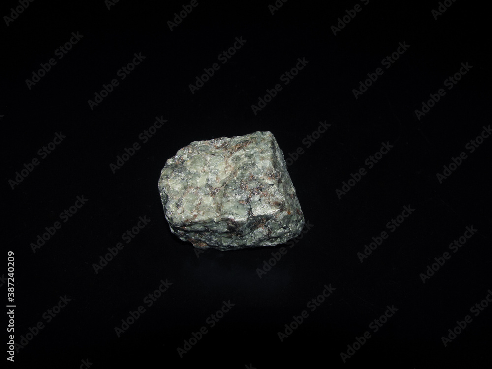a sample of the urtite rock is gray-green on a black background a sample of the urtite rock is gray-green on a black background
